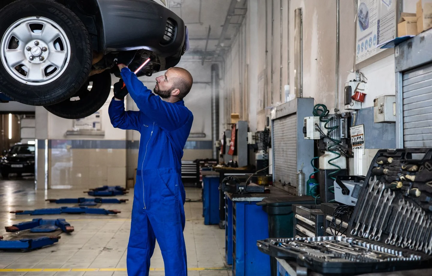 Technician inspecting a raised vehicle